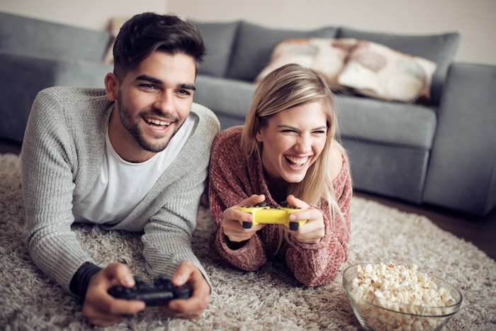 Young couple playing video games in their apartment.