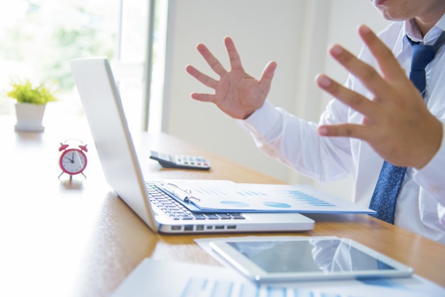 Young stressed handsome businessman working at desk in modern of