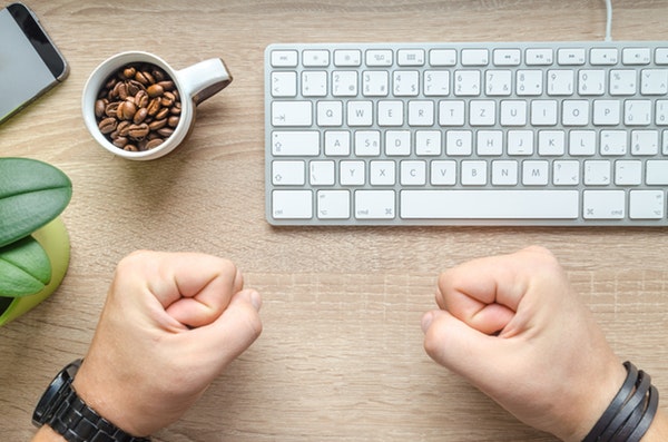 Closed fist near a white keyboard 