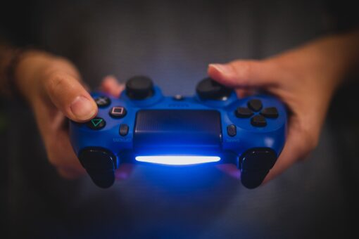 A man holding a light up controller, whis is one of the best PS4 accessories