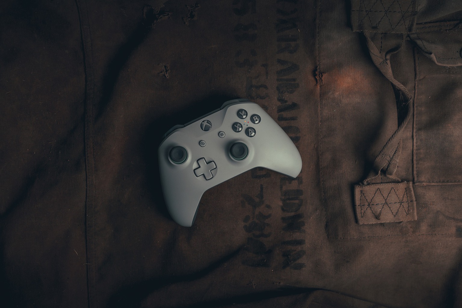 An Xbox controller on top of a military bag that would benefit from one of the best Xbox One travel cases